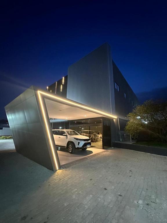 Un coche aparcado delante de un edificio por la noche en 232 Concept Hotel, en Caruaru