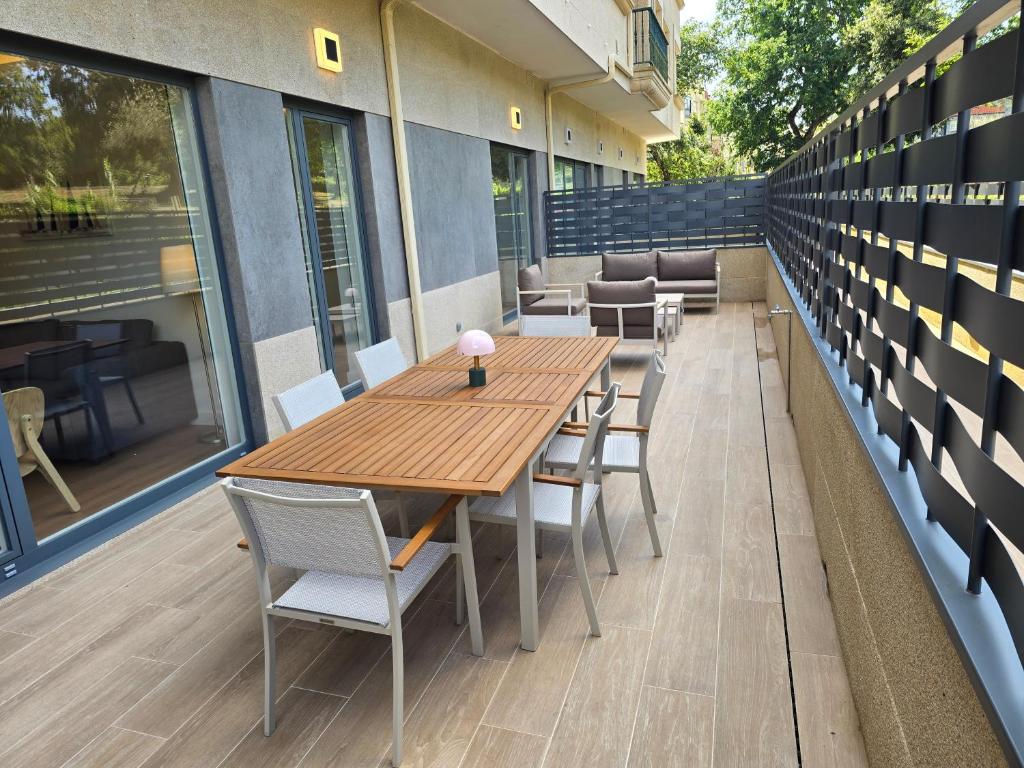a wooden table and chairs on a patio at Piso de lujo con gran terraza in Sanxenxo