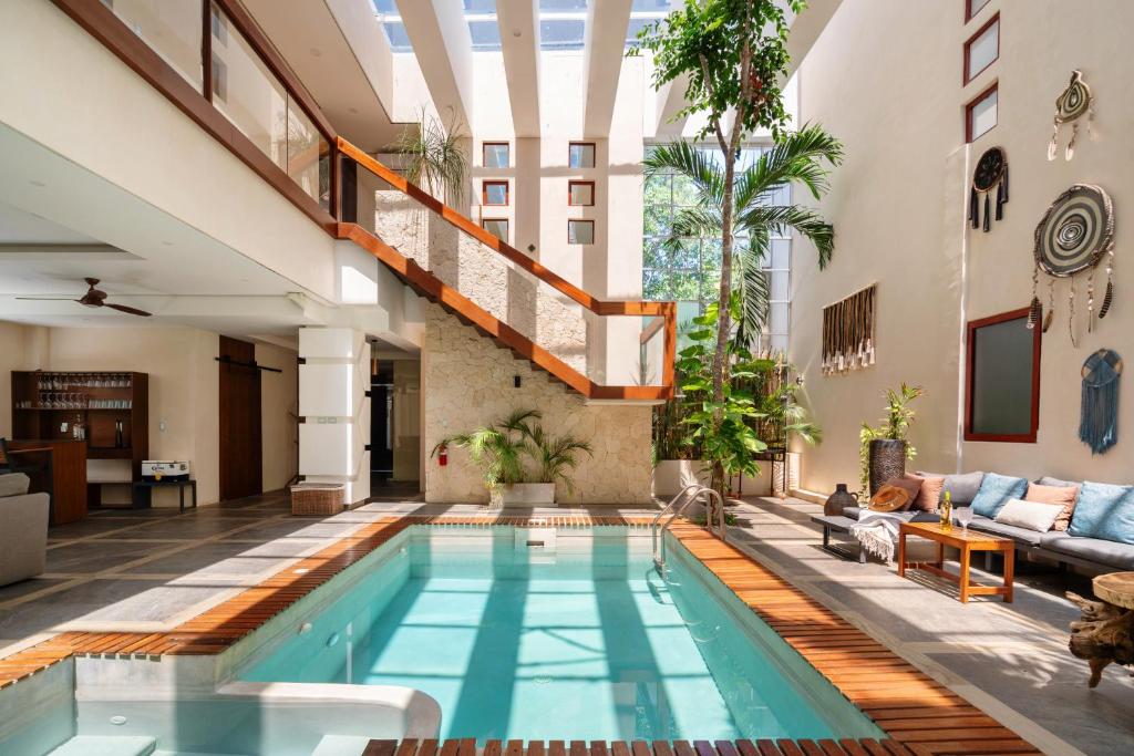 an indoor pool in a building with a staircase at 9Br Luxury Villas Aldea Zama, Private Pools & Gym! in Tulum