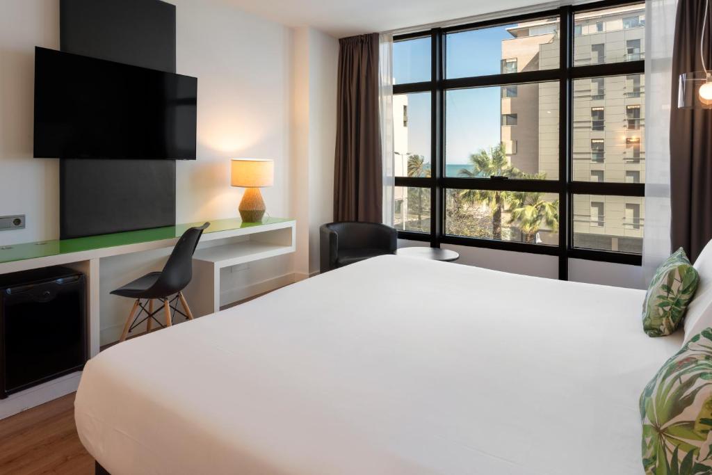 a hotel room with a large bed and a window at Catalonia Málaga in Málaga