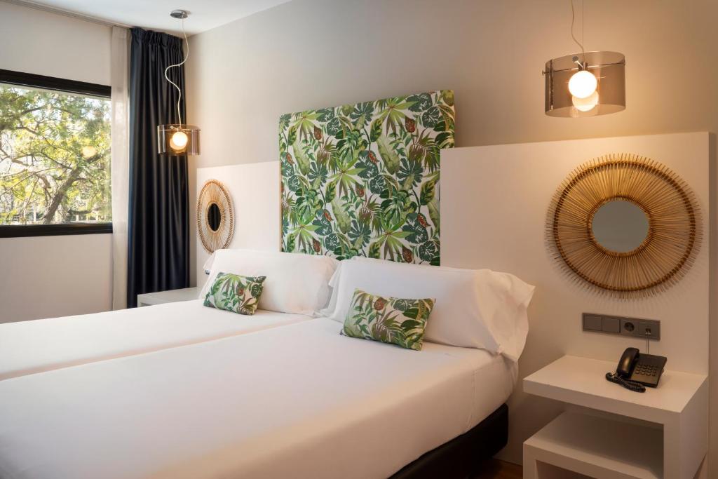 a bedroom with a white bed and a mirror at Catalonia Málaga in Málaga