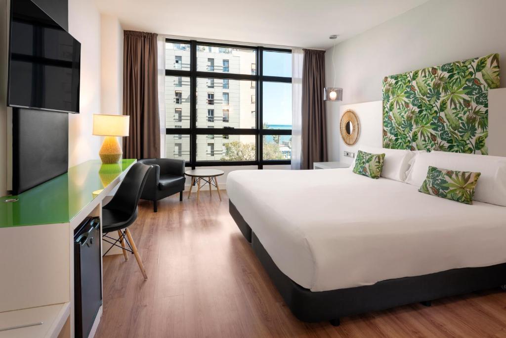 a hotel room with a bed and a desk at Catalonia Málaga in Málaga