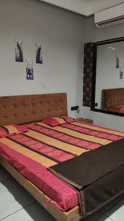 Un dormitorio con una cama grande con un espejo grande. en Shree Hariraj Guest House, en Jāmb