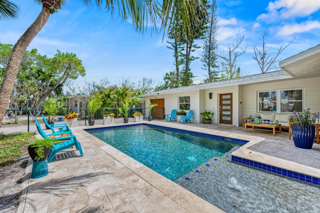 a swimming pool with chairs and a house at Beach Walk Cottage - 451 in Siesta Key