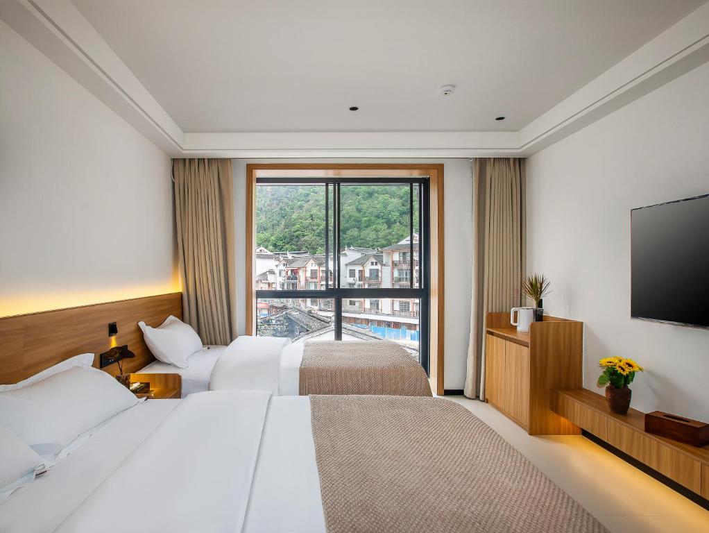 Postel nebo postele na pokoji v ubytování Fenghuang County Jiduo Intelligent Hotel
