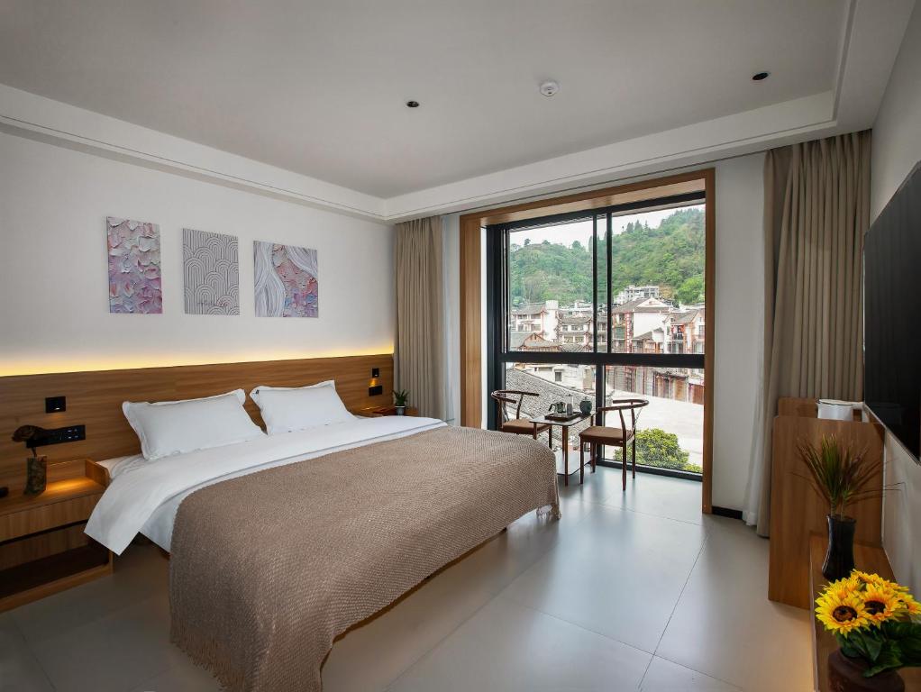 Postel nebo postele na pokoji v ubytování Fenghuang County Jiduo Intelligent Hotel