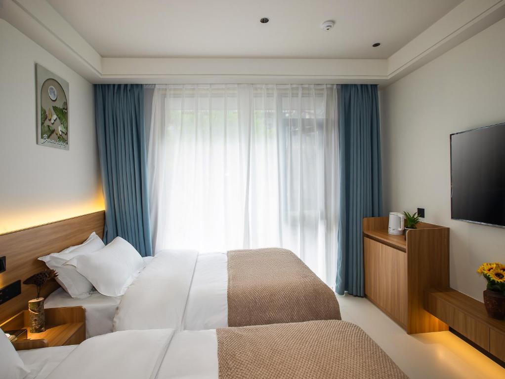 Postel nebo postele na pokoji v ubytování Fenghuang County Jiduo Intelligent Hotel