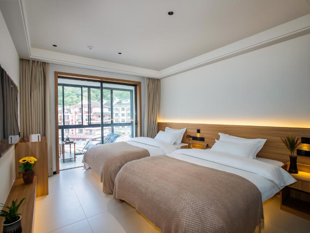 Postel nebo postele na pokoji v ubytování Fenghuang County Jiduo Intelligent Hotel