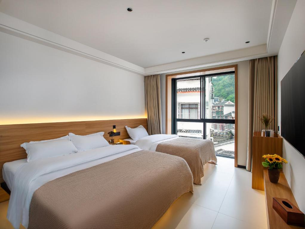 Postel nebo postele na pokoji v ubytování Fenghuang County Jiduo Intelligent Hotel