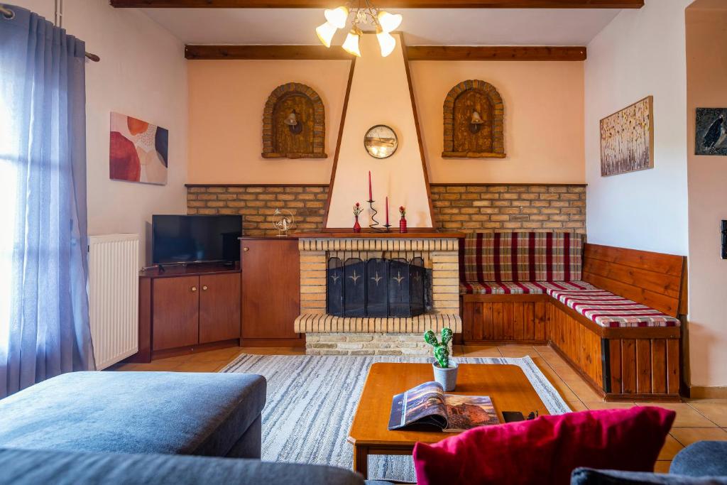 a living room with a fireplace and a couch at Casa Corfina in Sinarádes