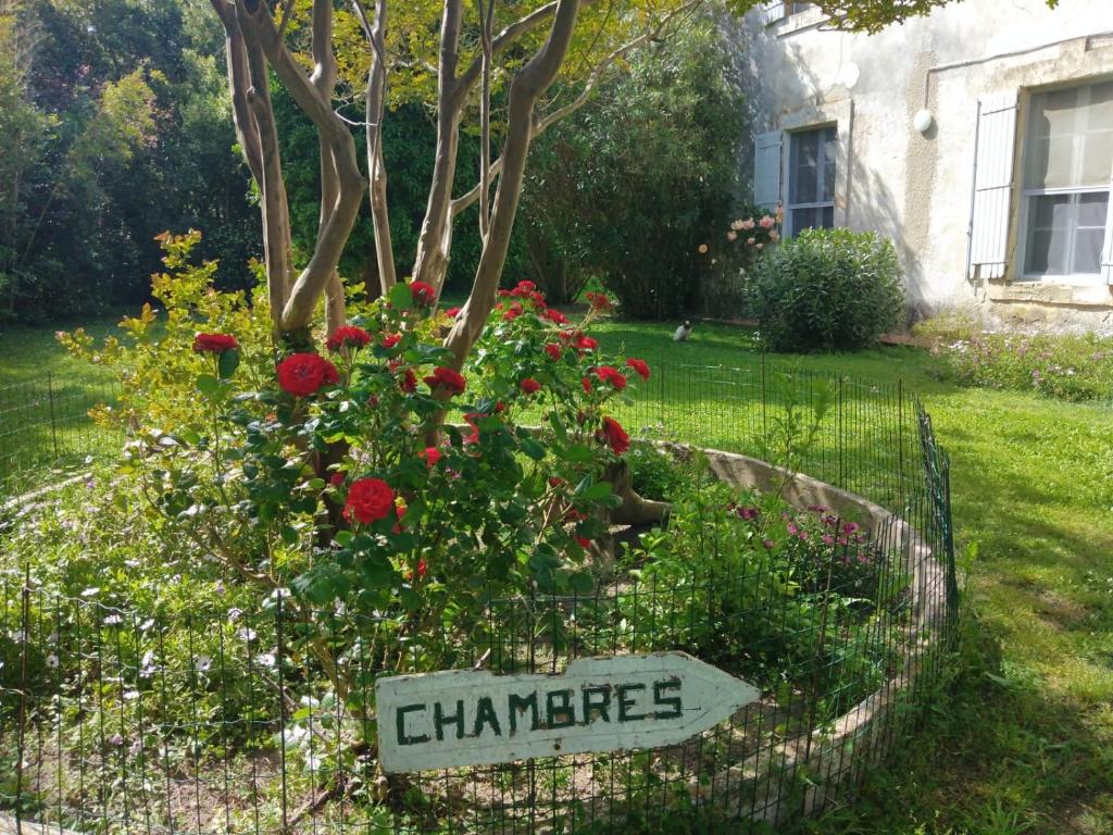 un cartello in un giardino con fiori in un cortile di Le Mas d'Icard a Saintes-Maries-de-la-Mer