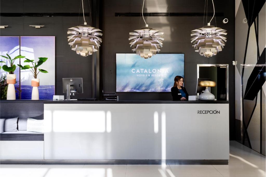 a woman is standing behind a counter in a store at Catalonia Málaga in Málaga