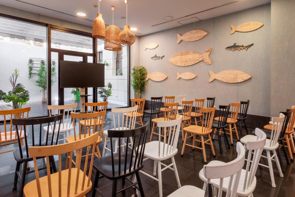 a restaurant with tables and chairs and a wall with fish on it at Catalonia Málaga in Málaga