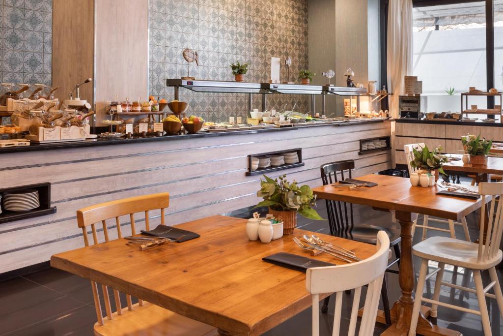a restaurant with a wooden table and chairs and a counter at Catalonia Málaga in Málaga