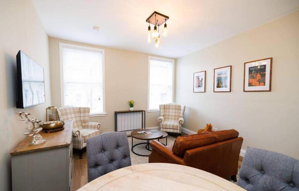 a living room with a couch and a table and chairs at Stylish 1-Bed Apartment in the Heritage Quarter in Dunfermline