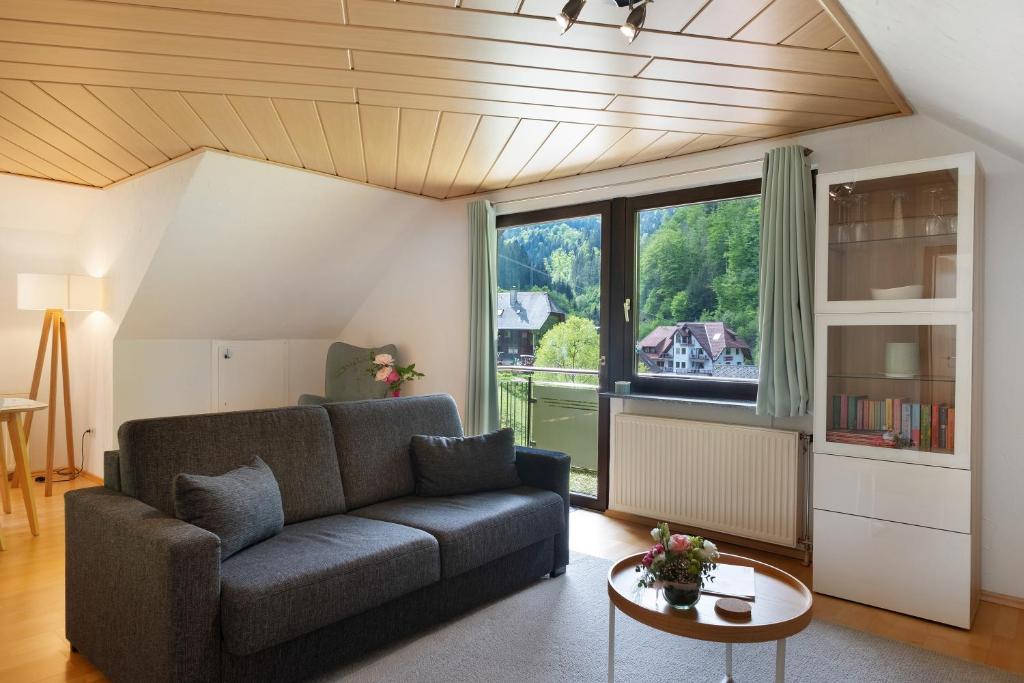 a living room with a couch and a large window at Ferienwohnung Glashütte in Sankt Märgen