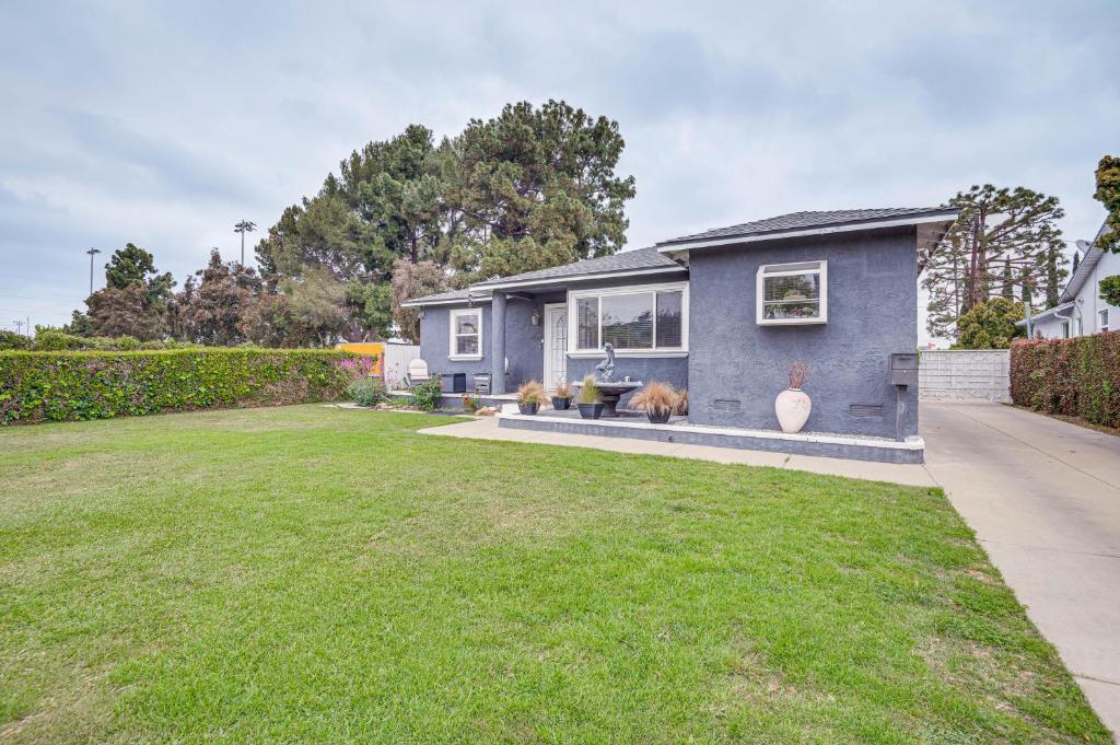 a blue house with a yard at 8 Mi to Dtwn Home with Fireplace and Games in LA! in Los Angeles