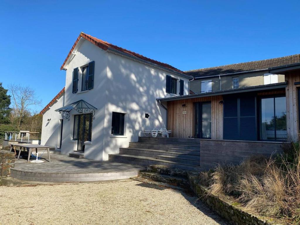 ein weißes Haus mit Treppe und einem Picknicktisch in der Unterkunft Villa La Foliotte in Saint-Pair-sur-Mer