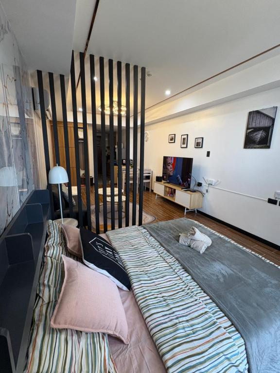 マニラにあるSybaysuites staycation near Okada COD MOA NAIAの部屋にある大きなベッドの上に猫が横たわっている