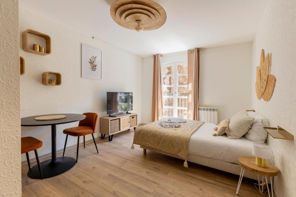 une chambre avec un lit, une table et une télévision dans l'établissement Travel Homes - The Pfeffel, 2m walk Little Venice, à Colmar