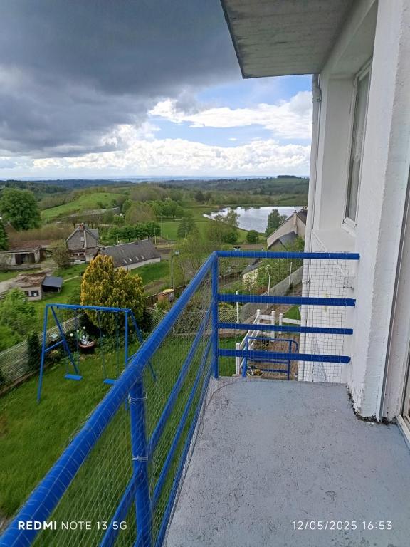 une balustrade bleue sur un balcon avec vue sur une rivière dans l'établissement Le lac, la neige,la vue, à La Tour-dʼAuvergne
