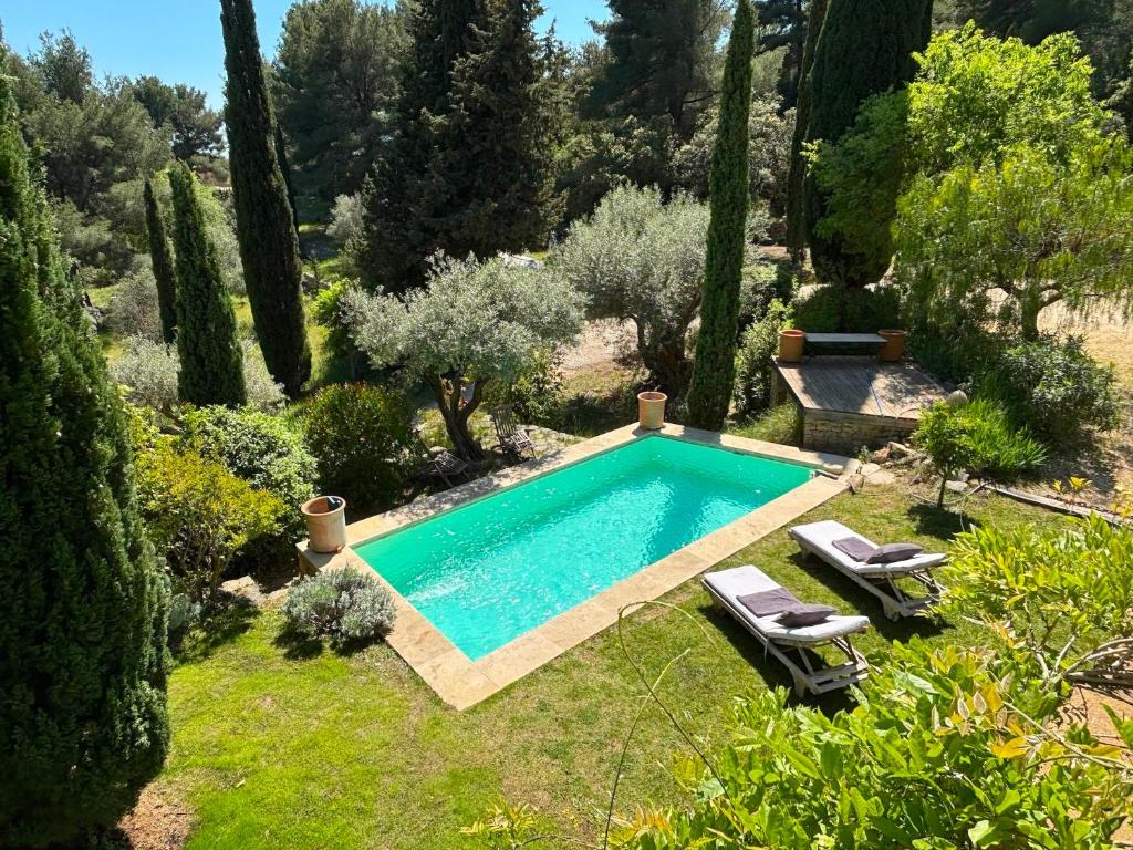 - une piscine dans un jardin avec 2 chaises longues dans l'établissement Villa Micéa, à Sanary-sur-Mer