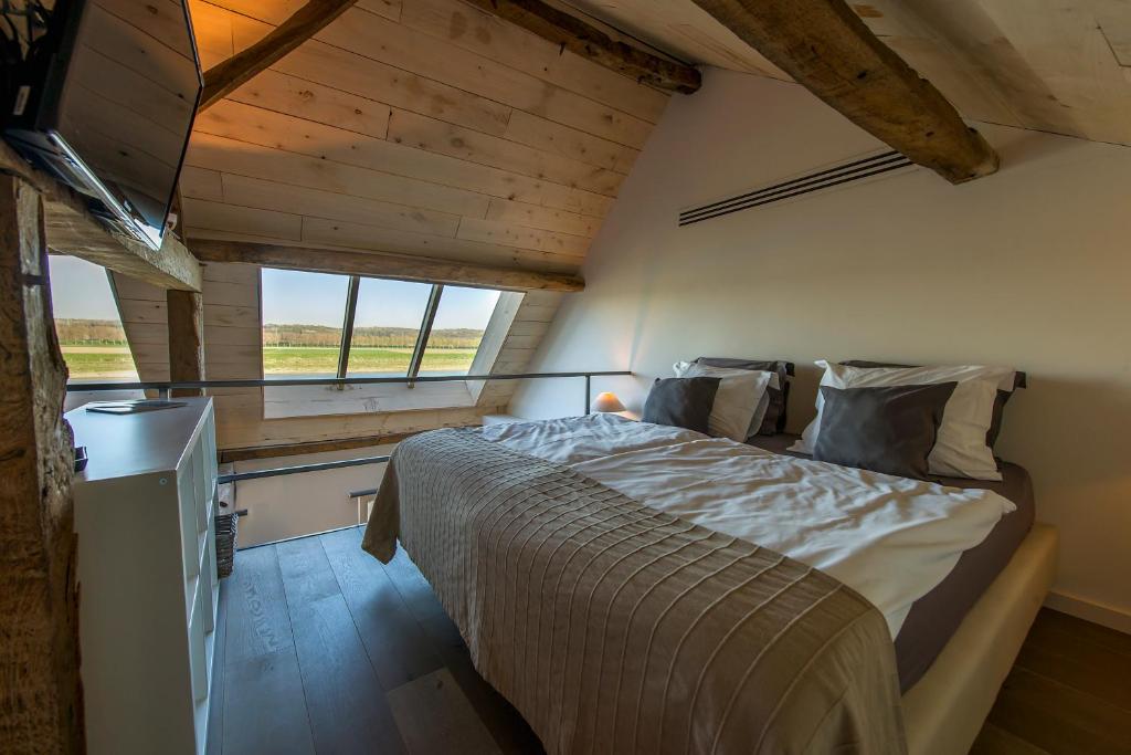 a bedroom with a bed in a room with a window at Holiday Home Janssen & Janssen in Maasmechelen