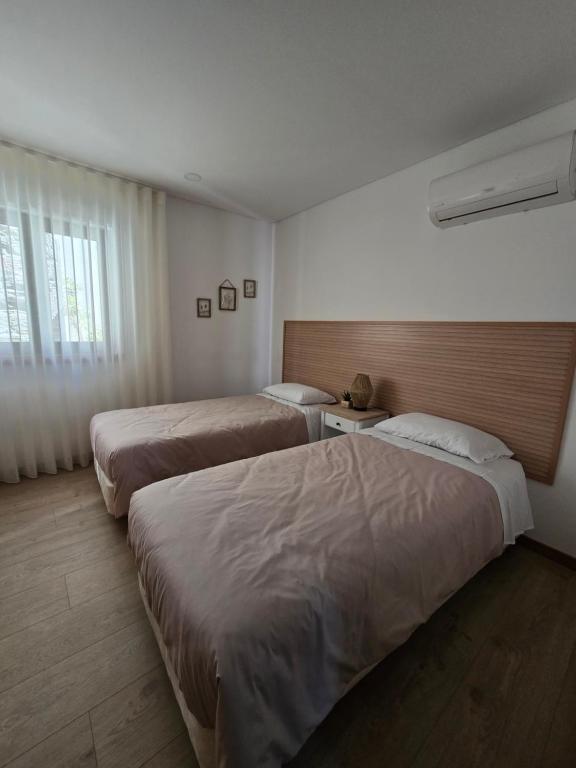 ein Hotelzimmer mit zwei Betten und einem Fenster in der Unterkunft Vivenda Branca Martinho II in Peso da Régua