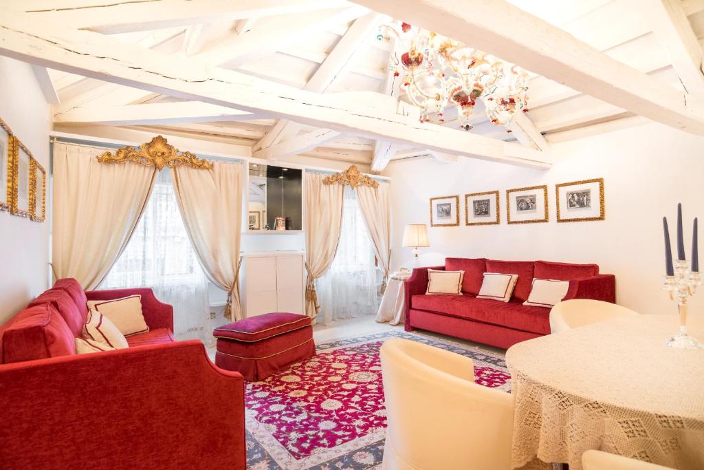 een woonkamer met rode banken en een tafel bij WellVenice Fenice in Venetië