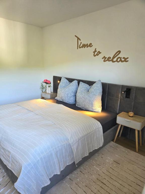a bedroom with a bed with a sign that reads time to relax at Ferienhaus Kronweiler in Kronweiler