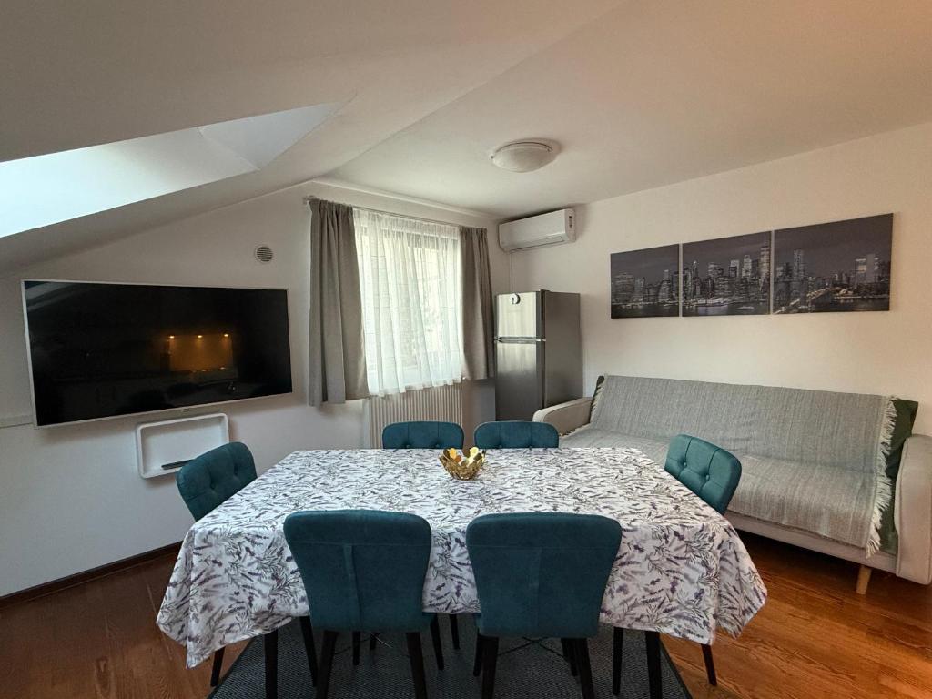 a dining room with a table and blue chairs at Emun Grigo Lofthouse in Cluj-Napoca