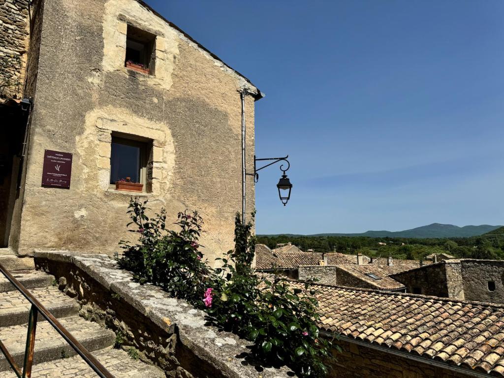 an old building with a window and a pink flower at Maison Châteaux Lavandes in Grignan