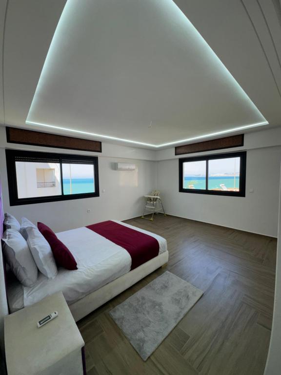タンジェにあるappartement 69 vue sur mer 3 chambreの大きなベッドと2つの窓がある寝室