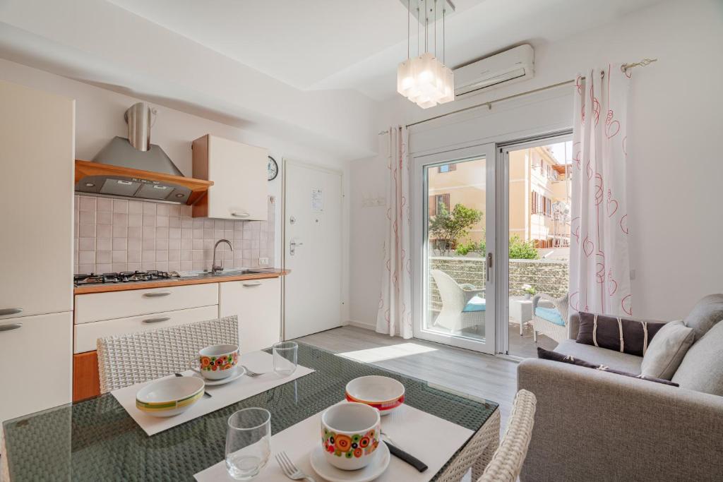 a kitchen and a living room with a table at Appartamento Veronese in Olbia
