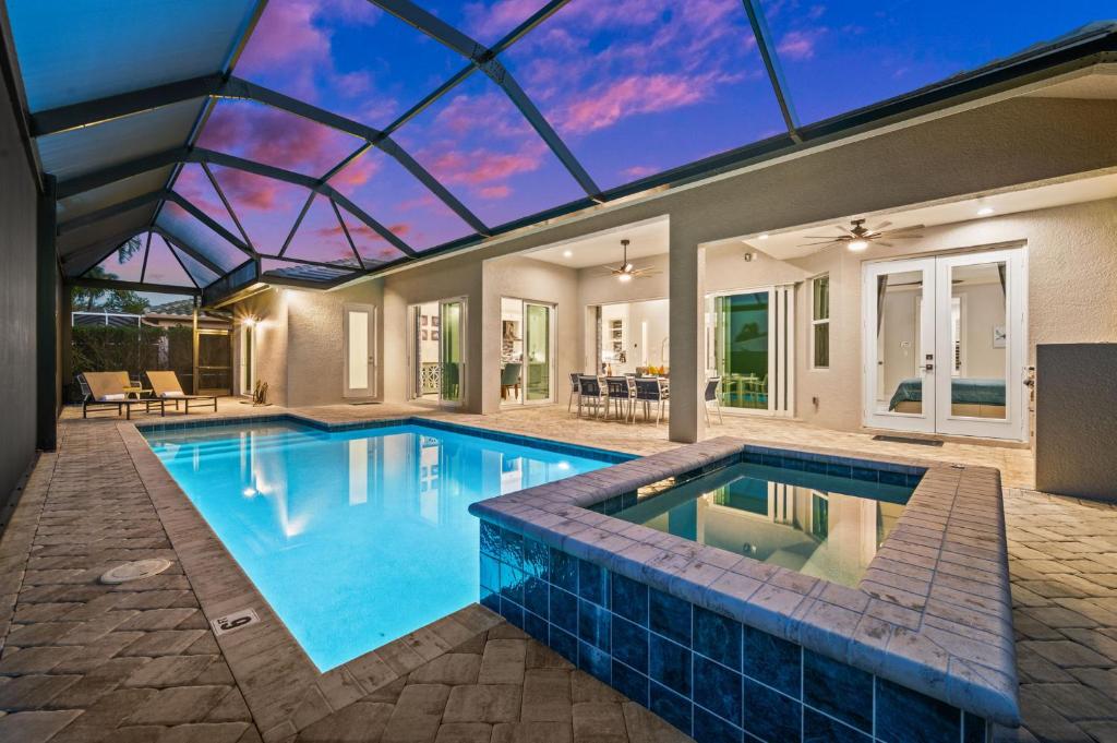 a swimming pool in a house with a glass ceiling at Casa Palma - 5 Min to Beach, Heated Pool, Hot Tub, New Build in Marco Island