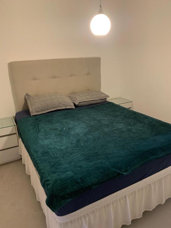 una camera da letto con un letto grande con una coperta verde di Casa de praia a Salvador