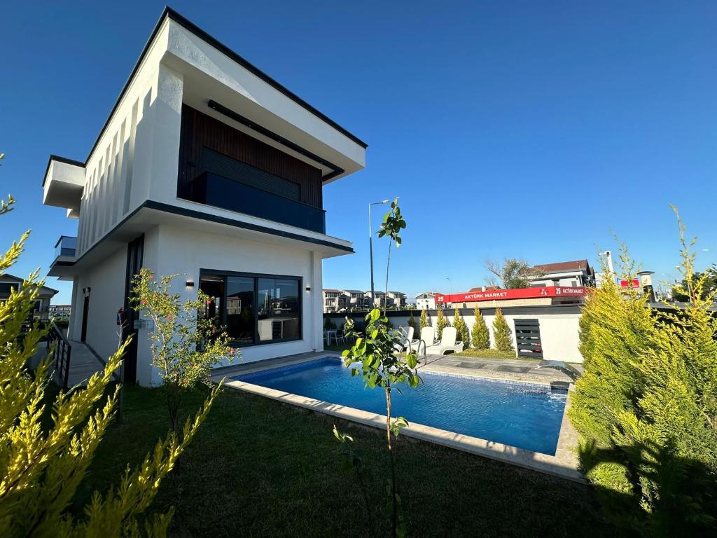 a house with a swimming pool in a yard at Belek Tatil Villa in Belek