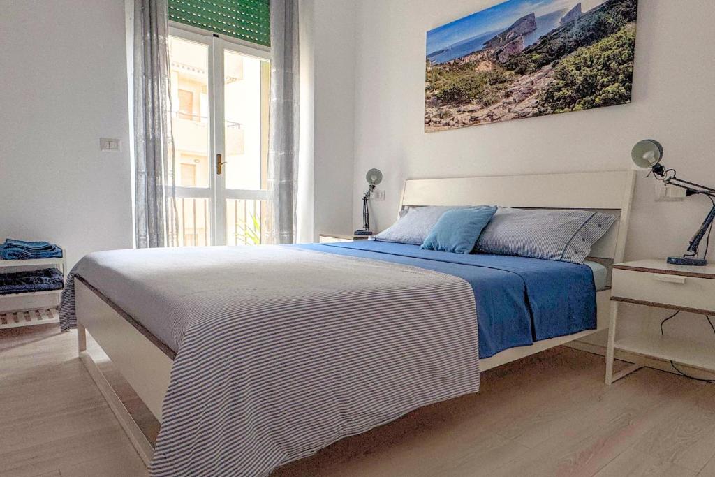 Un dormitorio con una cama con una manta azul y blanca. en Alegria Alghero, en Alghero