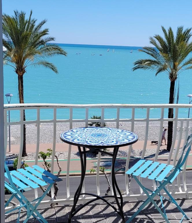 d'une table et de chaises sur un balcon donnant sur la plage. dans l'établissement Appartements Au Cros De Cagnes, à Cros-de-Cagnes