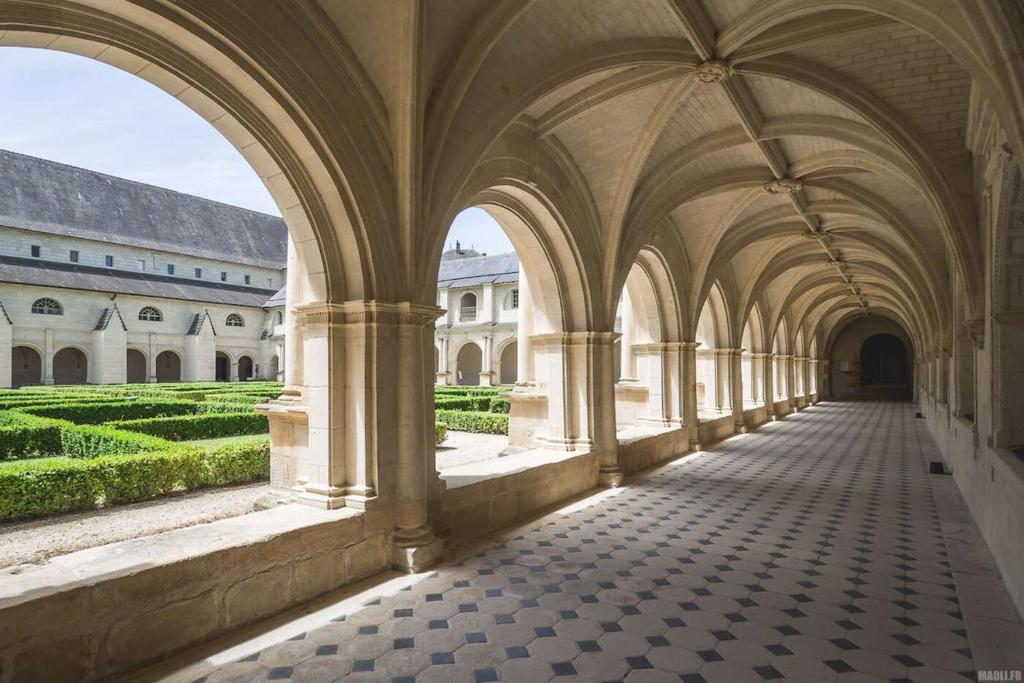 an arcade of a building with a view of a courtyard at La maison familiale des bords de Loire in Turquant