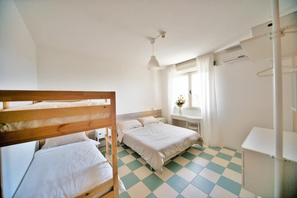 a bedroom with two bunk beds and a checkered floor at Hotel Happy in Marina di Pietrasanta