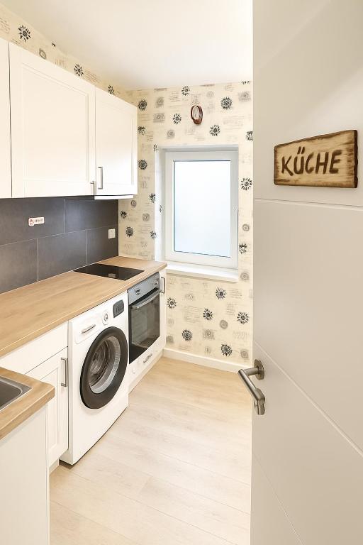 a kitchen with a washing machine and a window at Wohlfühlzimmer Marienheide in Marienheide