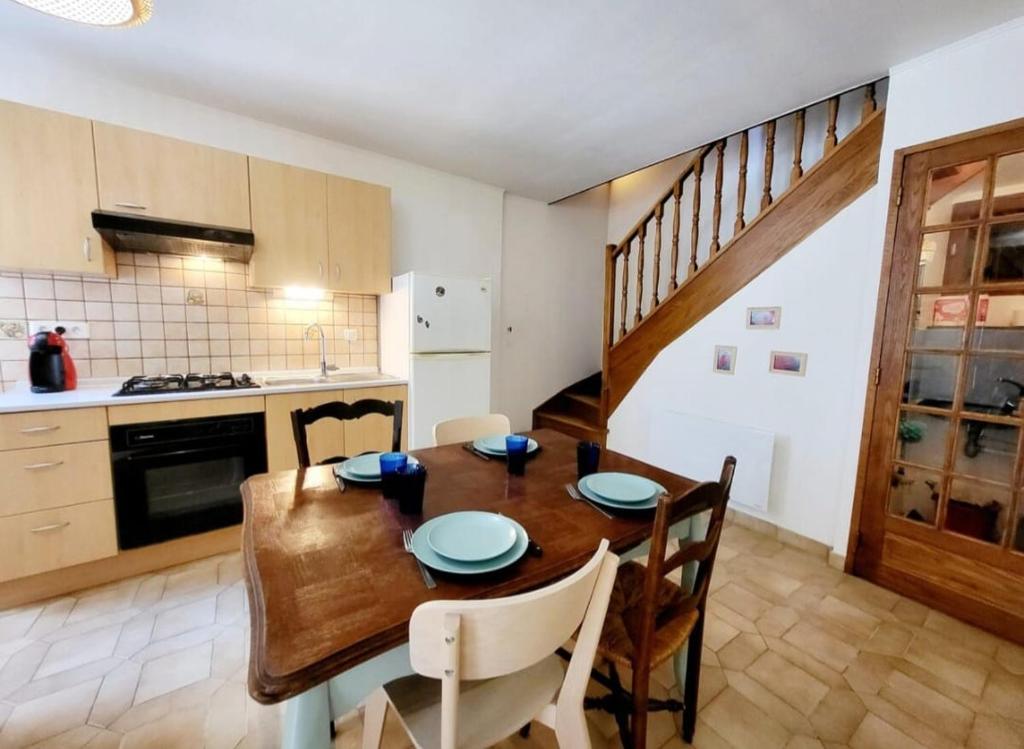 une cuisine et une salle à manger avec une table et des chaises en bois dans l'établissement La bulle à Thueyts Proche Pont du diable, à Thueyts
