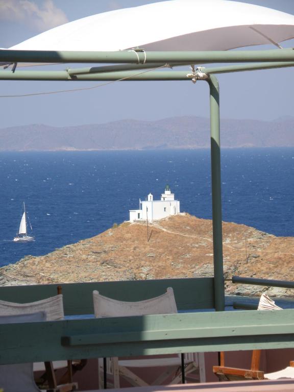a view of a small island in the ocean with a sailboat at Spitakia in Vourkari