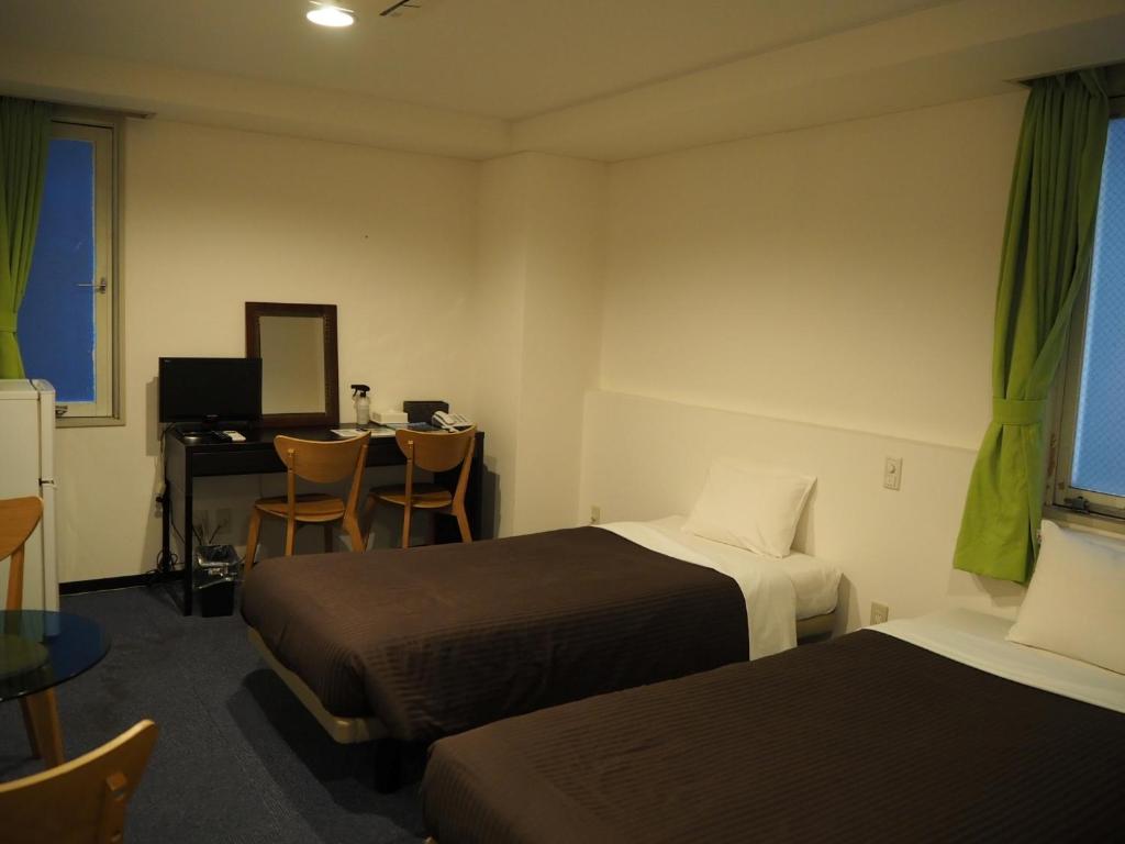 Postel nebo postele na pokoji v ubytování Grampus Inn Osaka Namba