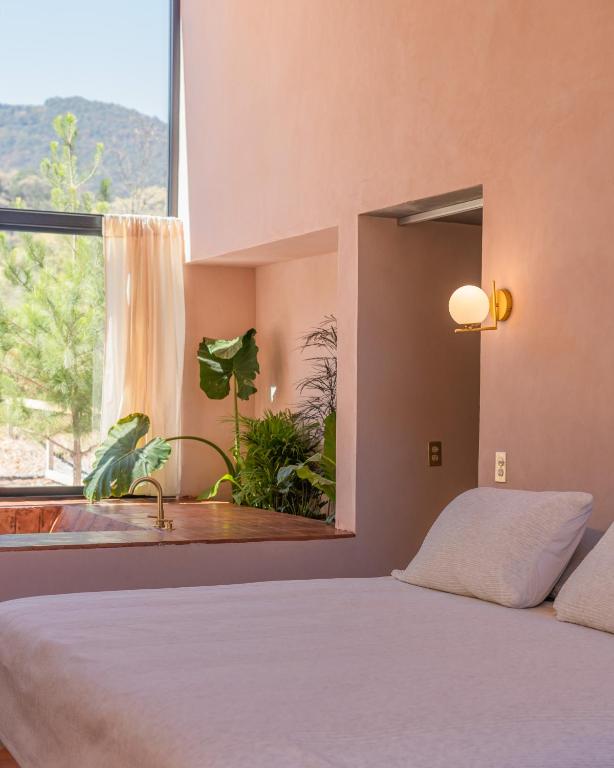 a bedroom with a bed and a large window at La Cabaña Rosa in Amealco