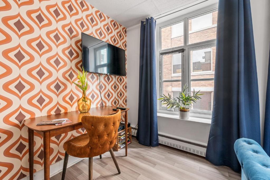 a room with a table and a tv on a wall at LOFT LE RÉTRO du Centre-Ville in Quebec City