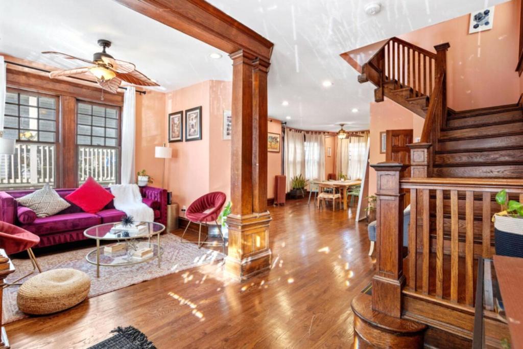 ein Wohnzimmer mit einem lila Sofa und einer Treppe in der Unterkunft 8BR 3BA Classic by Tropicana, Boardwalk, Beach in Atlantic City