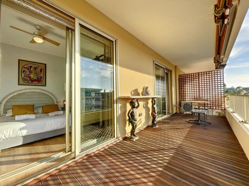 une chambre avec un balcon avec un lit et des portes vitrées dans l'établissement Cap d'Antibes 2P garage proche mer Hermitage, à Antibes