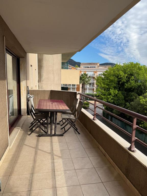 - un balcon avec une table et des chaises au-dessus d'un bâtiment dans l'établissement T2 climatisé au cœur de Cavalaire, avec terrasse, garage, proche des plages et commerces- Onda di mar, à Cavalaire-sur-Mer